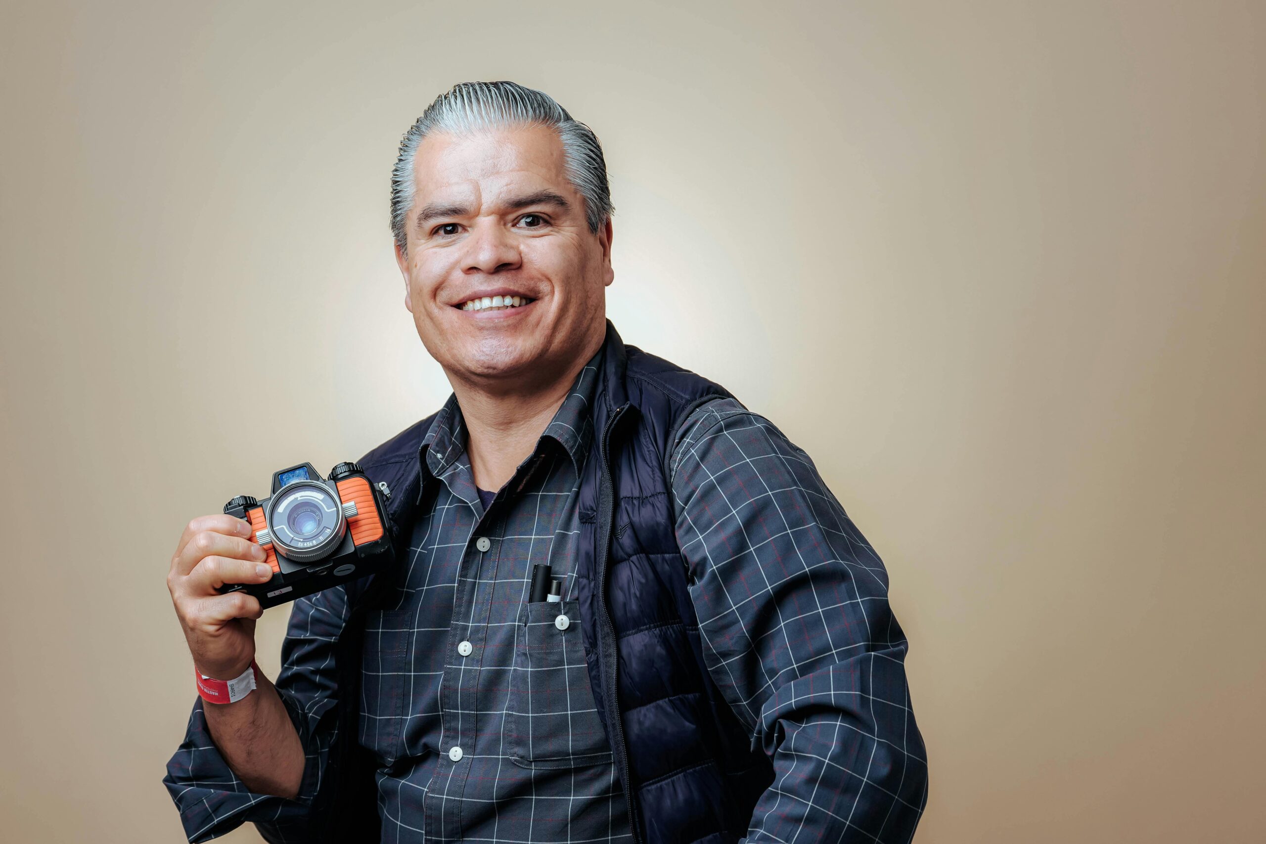 Smiling photographer holding a camera with confidence knowing their gear is insured