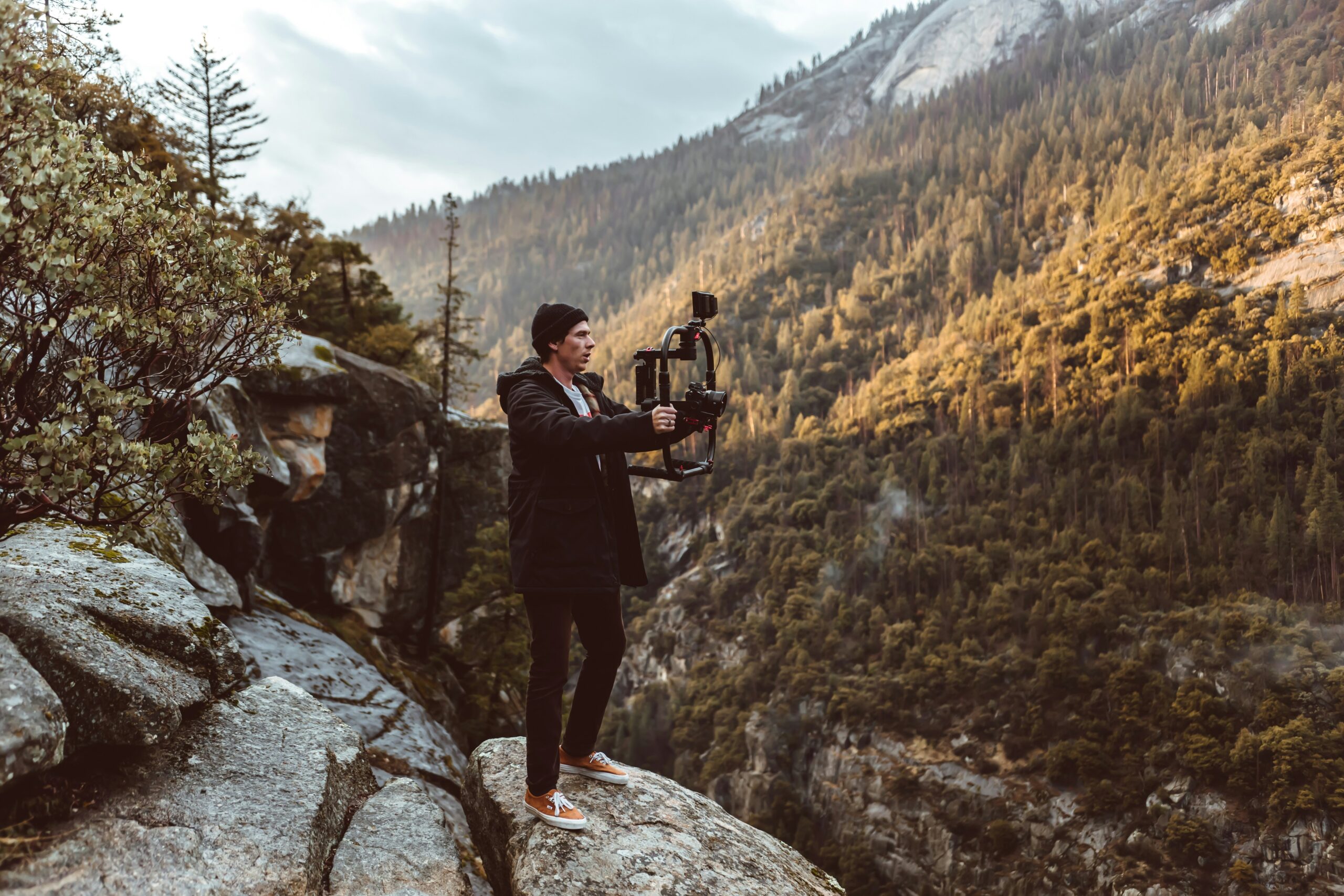Travel photographer holding a drone near scenic mountains